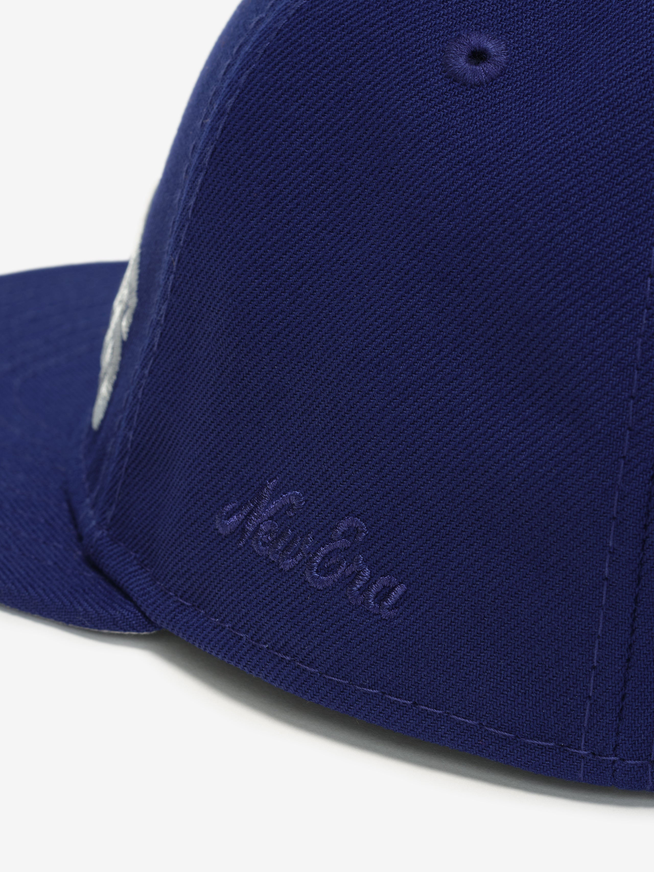 Close-up angled view of navy Giants 9Fifty RC Snapback highlighting embroidered New Era logo on side panel, gallery image 0