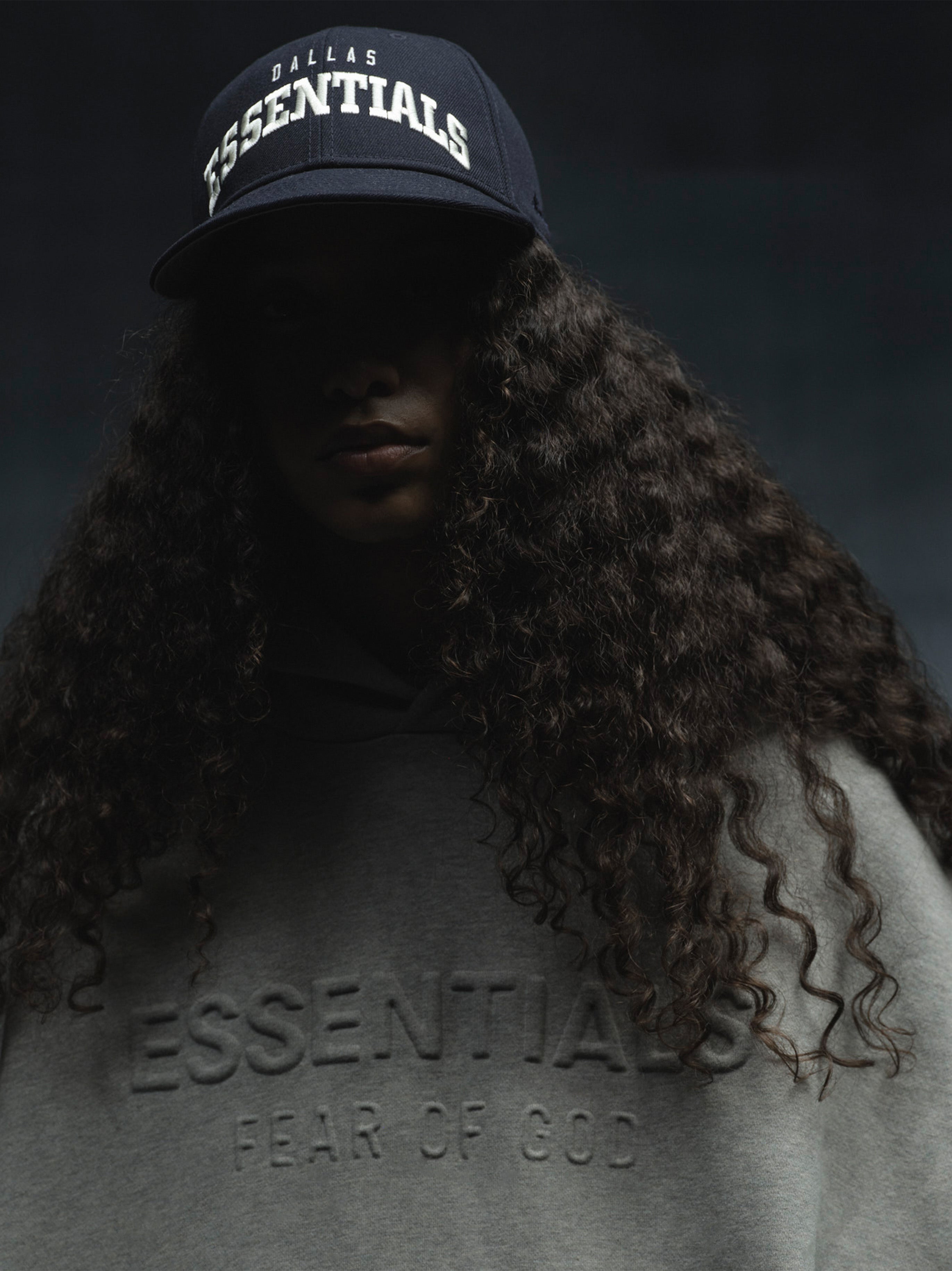Low-lit front view of navy Cowboys 9Fifty RC Snapback with bold white Dallas Essentials embroidery, gallery image 0