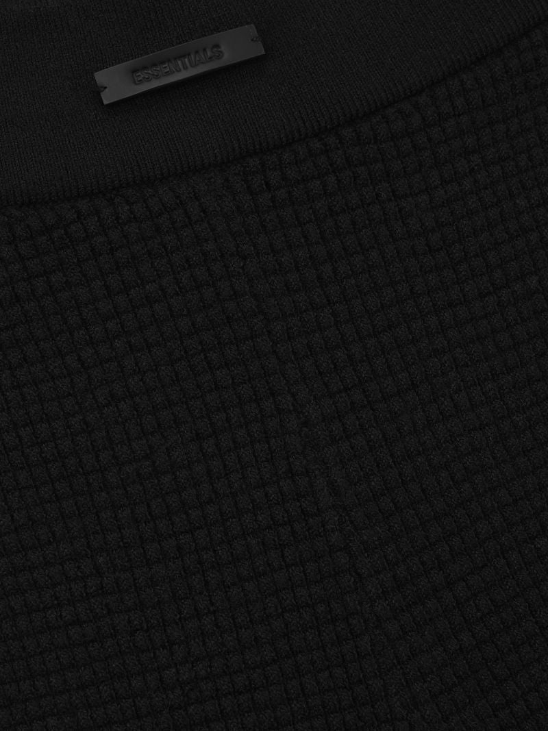 close-up of black poly-nylon waffle knit fabric with textured grid pattern and ESSENTIALS logo detail on waistband