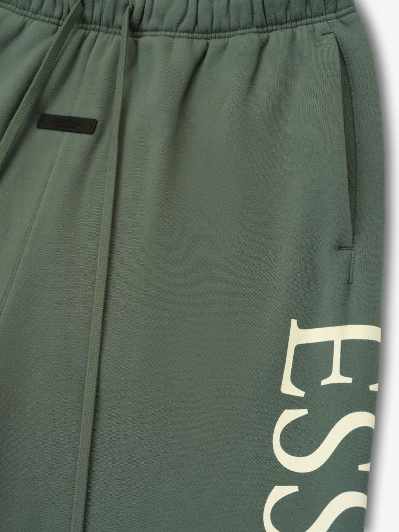 Close-up of olive green FAMU Lounge Sweatpant pocket area with elastic waistband and partial cream ESS text, file NPMV1n8Q.jpg