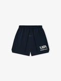 Flat lay of navy blue shorts with elastic waistband, drawstring, and white "USA ESSENTIALS" graphic on front left leg