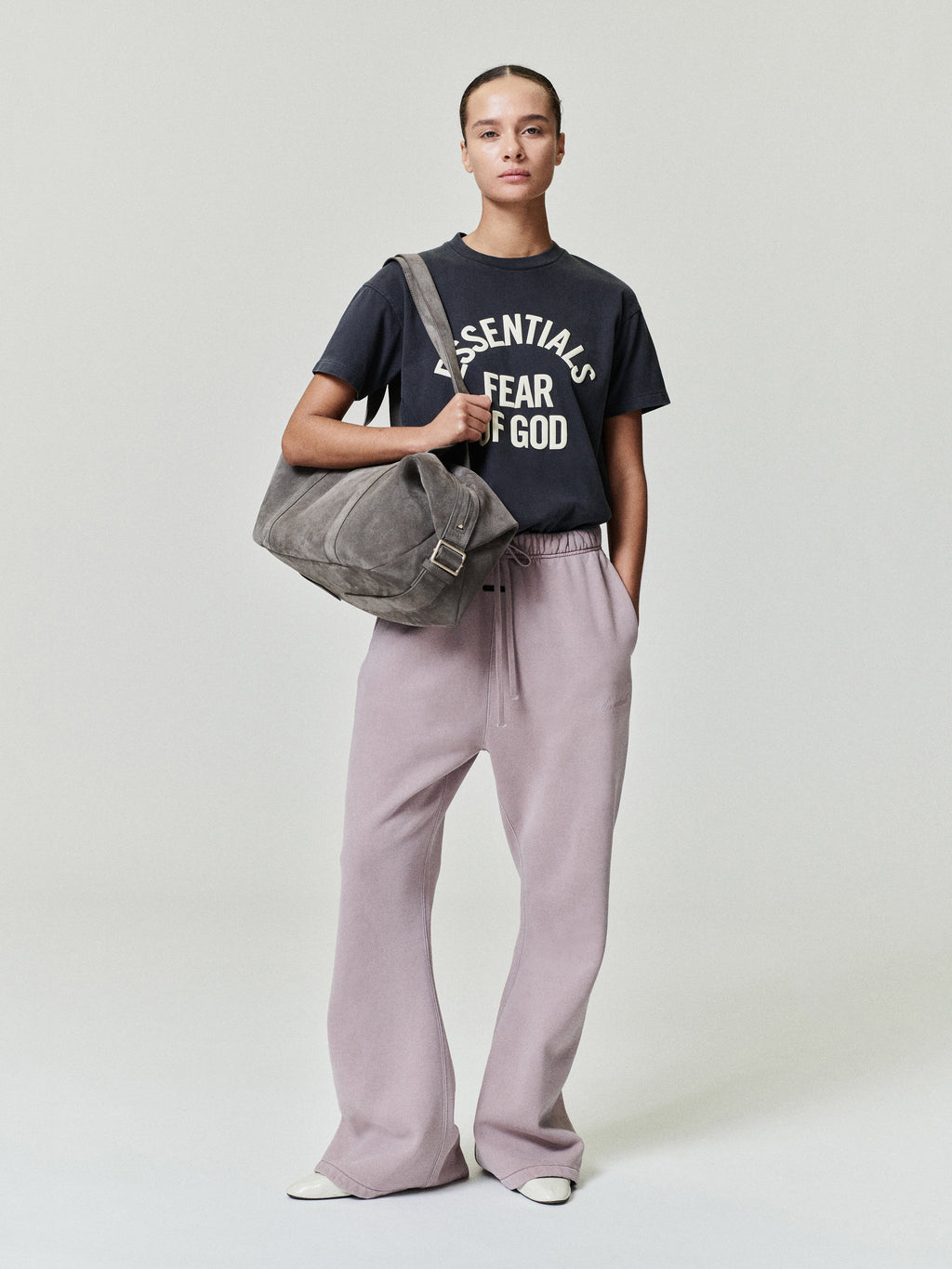 woman wearing relaxed fit flare sweatpants in muted mauve with elastic waistband and front pockets