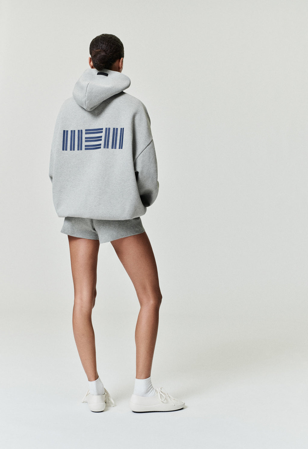 Model wearing grey Memphis Grizzlies 90'S Hoodie viewed from back with navy blue graphic, gallery position 0