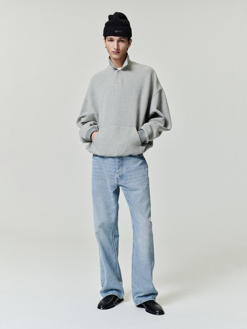 man wearing light blue vintage wash straight leg denim jeans with five-pocket design and black beanie