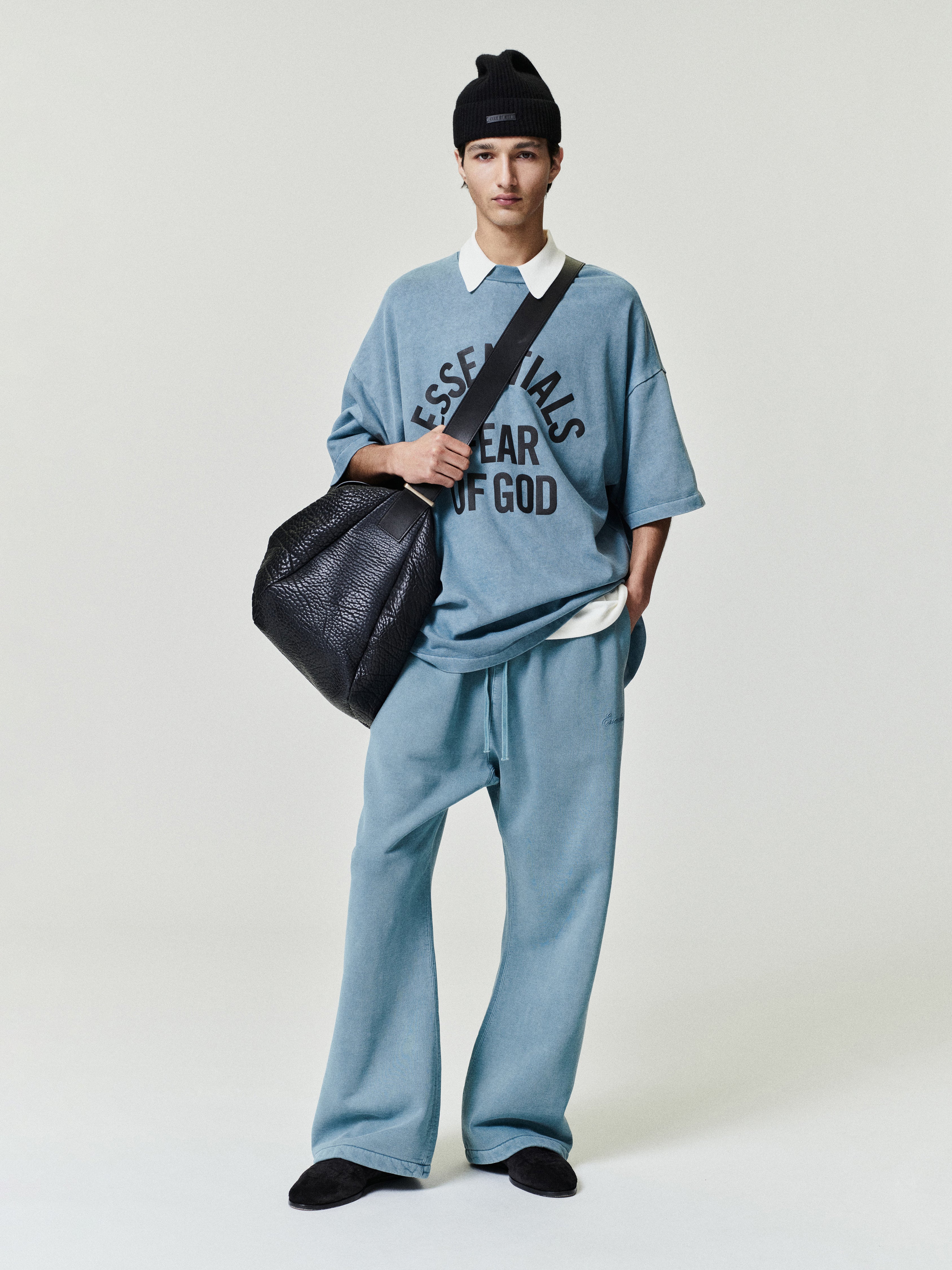 blue oversized 90s-style heavyweight cotton tee with ESSENTIALS FEAR OF GOD text, paired with matching relaxed pants