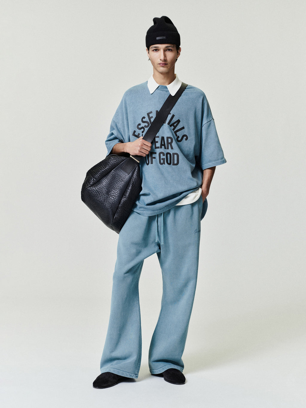 man wearing relaxed fit vintage blue fleece flare sweatpants with drawstring waistband and oversized t-shirt