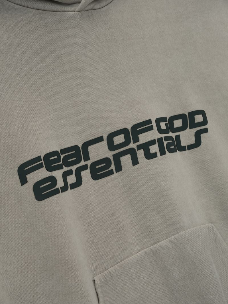 Close-up of muted beige Heavy Fleece 90s Hoodie showing angled Fear of God Essentials logo above kangaroo pocket mjtA4iGw.jpg gallery 0