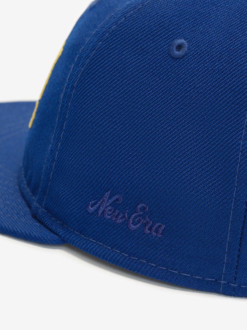 Close-up of blue Warriors 9Fifty RC Snapback showing purple New Era embroidery on side panel wfmNWnOA.jpg gallery 0